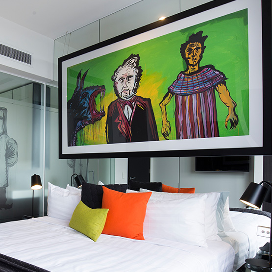 An indoor-outdoor hotel space with seating and an umbrella
